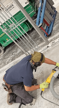 A man wearing ear muffs and working on a machine.