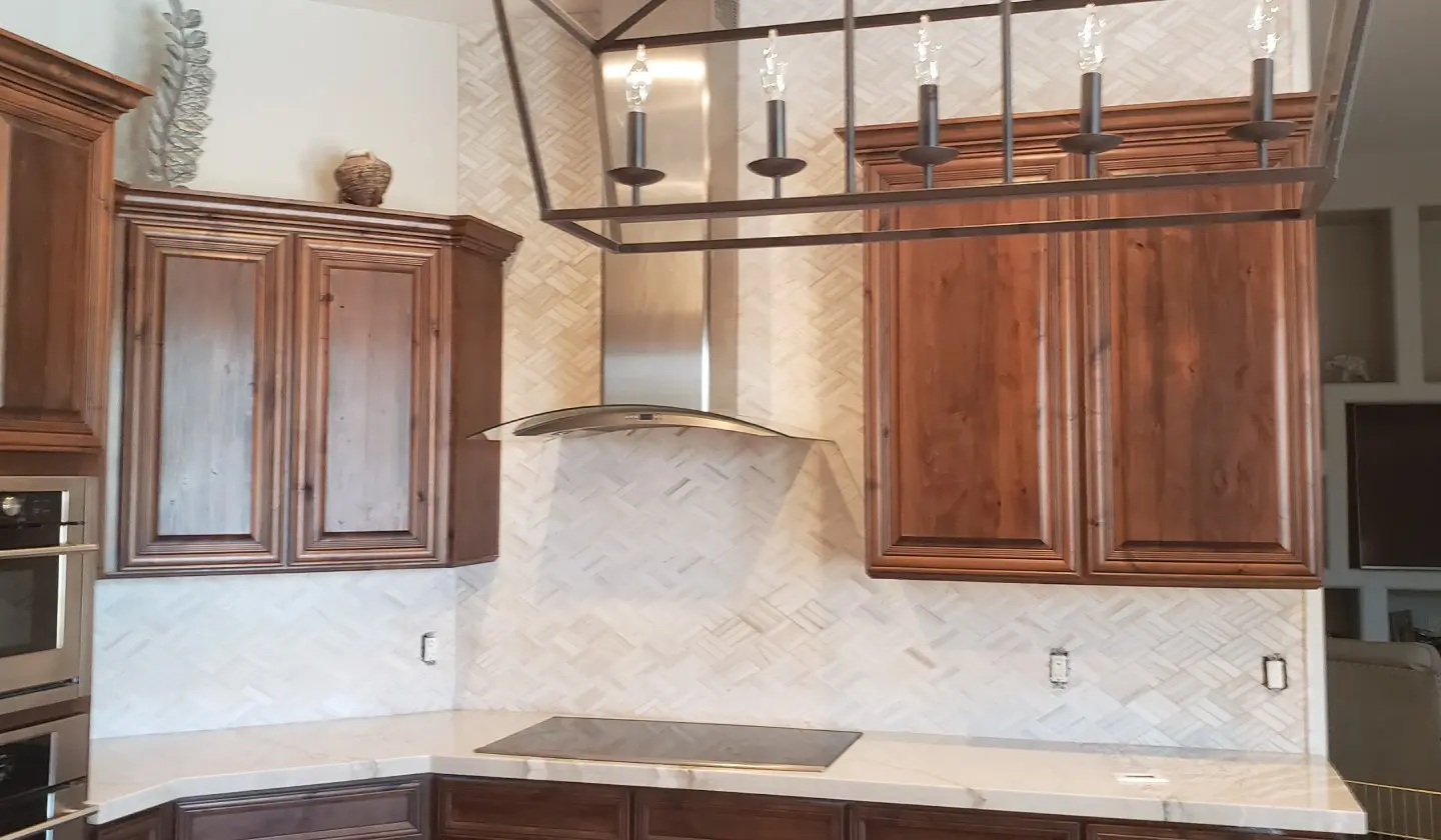 A kitchen with wooden cabinets and white tile.