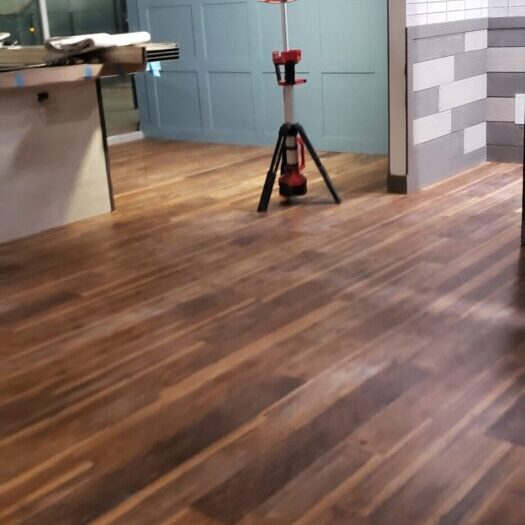 A wooden floor with a red jack stand in the middle of it.