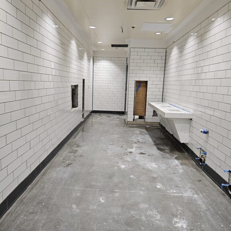 A bathroom with white brick walls and floor.