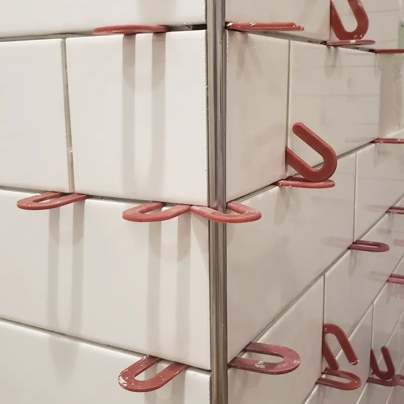 A wall with many red hooks on it